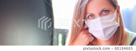 Portrait of young beautiful woman in protective mask on street 88184683