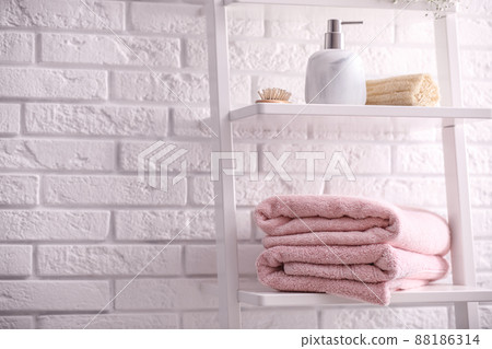Clean towels on shelving unit in bathroom. Space for text 88186314