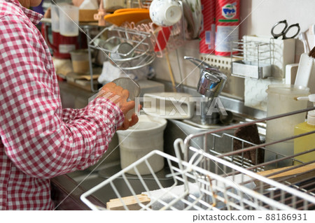 在不整潔的廚房裡洗杯子的老婦人 88186931