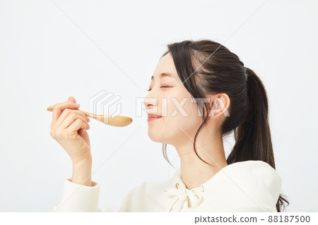 A woman eating with a spoon A woman eating with a spoon 88187500