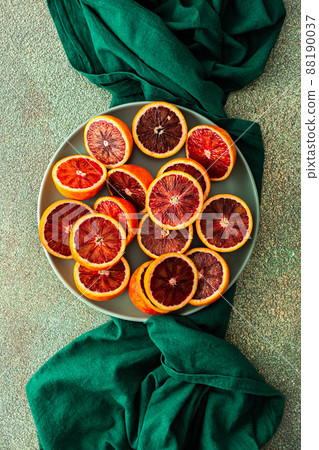 Blood orange in a plate on a green tablecloth Blood orange in a plate on a green tablecloth 88190037
