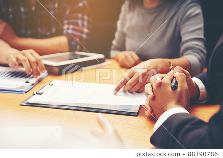 A group of business people are meeting to analyze data for marketing plan A group of business people are meeting to analyze data for marketing plan 88190786