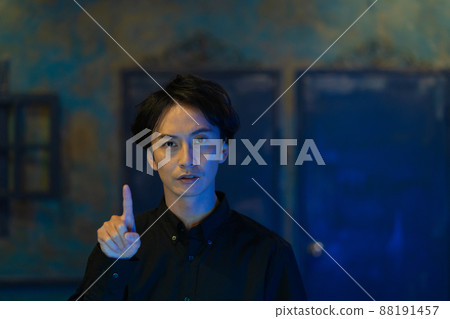 一個年輕人用手指指著藍光 88191457