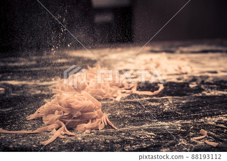 Home fresh raw pasta on the kitchen table black concrete, sprinkle with flour. Home fresh raw pasta on the kitchen table black concrete, sprinkle with flour. 88193112