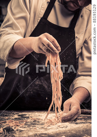 The chef makes fresh spaghetti from scratch. 88193129