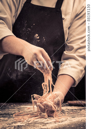 The chef makes fresh spaghetti from scratch. 88193130