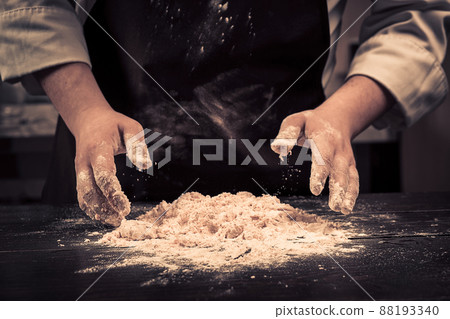The chef makes dough for pasta on a wooden table The chef makes dough for pasta on a wooden table 88193340