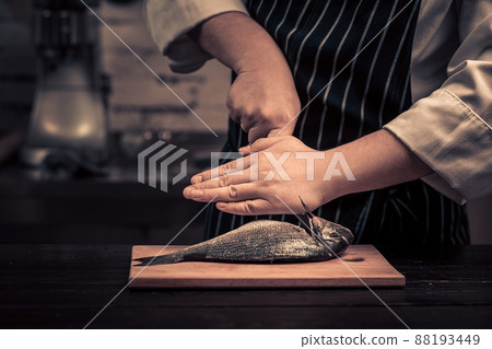 Chef cutting the fish on a board Chef cutting the fish on a board 88193449