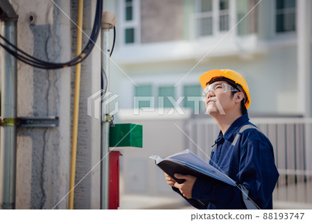 An Engineer is reading a document and checking the communication line. An Engineer is reading a document and checking the communication line. 88193747