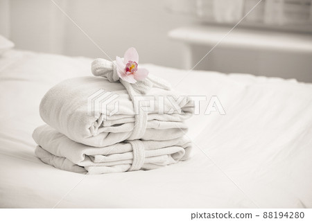 Clean folded bathrobes on bed in room, space for text 88194280