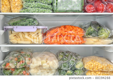 Plastic bags and containers with different frozen vegetables in refrigerator 88194288