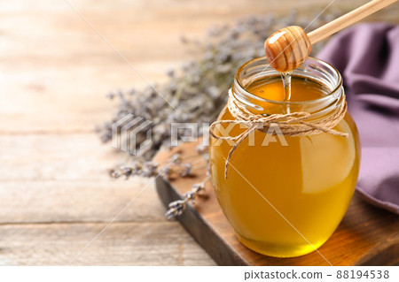 Tasty fresh sunflower honey with wooden dipper on table, closeup 88194538