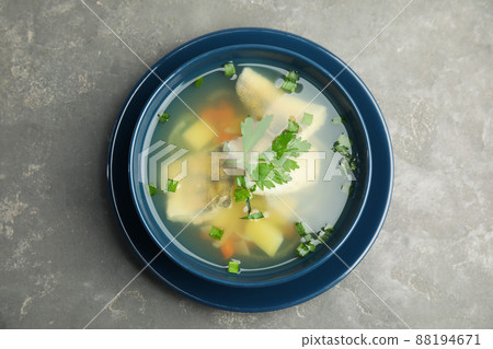 Delicious fish soup in bowl on grey table, top view Delicious fish soup in bowl on grey table, top view 88194671