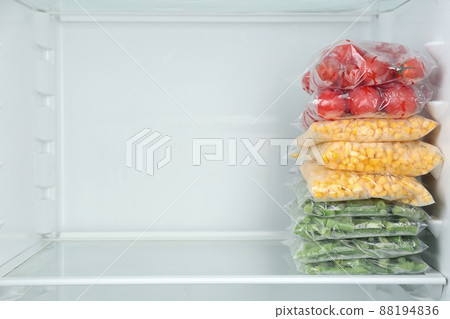 Plastic bags with different frozen vegetables in refrigerator 88194836