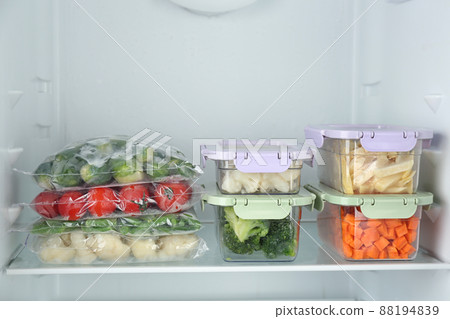 Plastic bags and containers with different frozen vegetables in refrigerator 88194839