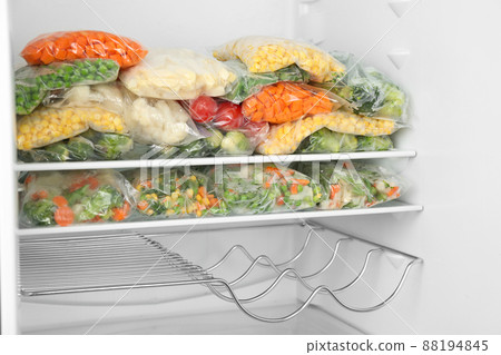 Plastic bags with different frozen vegetables in refrigerator 88194845