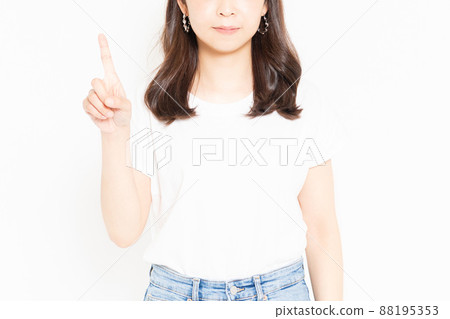 Young woman standing in front of a white background and wearing a T-shirt representing the number 1 by hand Young woman standing in front of a white background and wearing a T-shirt representing the number 1 by hand 88195353