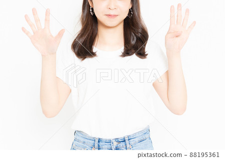 Young woman standing in front of a white background and wearing a T-shirt representing the number 9 by hand Young woman standing in front of a white background and wearing a T-shirt representing the number 9 by hand 88195361