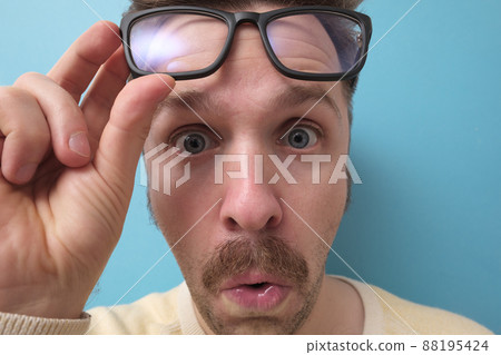 man with funny mustache having doubts and with confuse face expression on isolated blue background 88195424