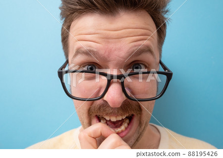 man with funny mustache having doubts and with confuse face expression on isolated blue background 88195426
