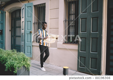 African American hipster guy 20s trying find some location on orientation paper African American hipster guy 20s trying find some location on orientation paper 88196308