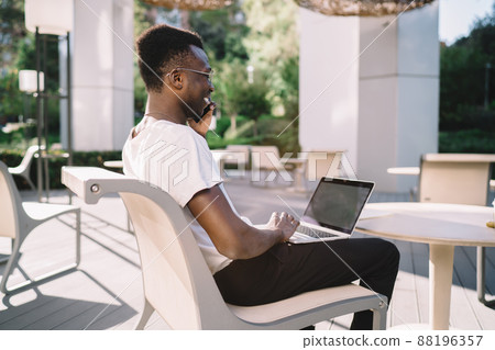 Young black man using smartphone on terrace hotel Young black man using smartphone on terrace hotel 88196357