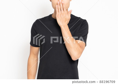 A man standing in front of a white background and making a secret gesture 88196709