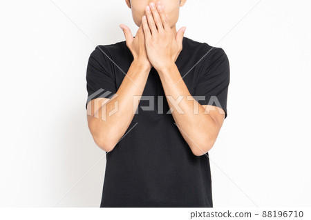 A man standing in front of a white background and making a secret gesture 88196710