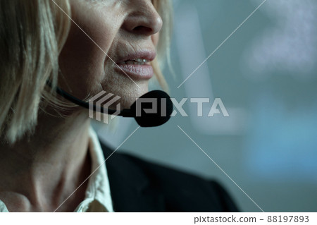 Part of face of mature confident female broker speaking in microphone 88197893