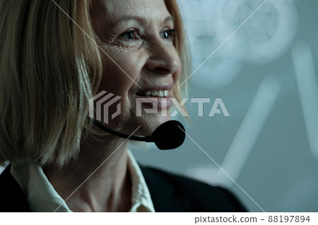 Face of happy mature businesswoman with microphone by her chin 88197894