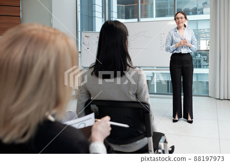 Young smiling business coach in formalwear communicating with audience 88197973