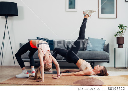 Home workout mother and daughter do bridge and gluteal bridge 88198322