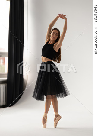 Beautiful ballerina dancing at studio in black dress, have training. 88198643