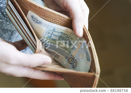 Russian rubles banknotes in hands during the war in Ukraine. Inflation, sanctions and the fall of the Russian economy concept. Falling cash savings and budget Russian rubles banknotes in hands during the war in Ukraine. Inflation, sanctions and the fall of the Russian economy concept. Falling cash savings and budget 88198738