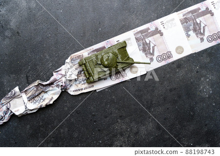 Economic crisis in Russia concept. Toy military tank on Russian rubles. War conflict in Ukraine, economic sanctions and inflation in Russia Economic crisis in Russia concept. Toy military tank on Russian rubles. War conflict in Ukraine, economic sanctions and inflation in Russia 88198743