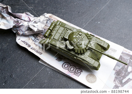 Economic crisis in Russia concept. Toy military tank on Russian rubles. War conflict in Ukraine, economic sanctions and inflation in Russia Economic crisis in Russia concept. Toy military tank on Russian rubles. War conflict in Ukraine, economic sanctions and inflation in Russia 88198744