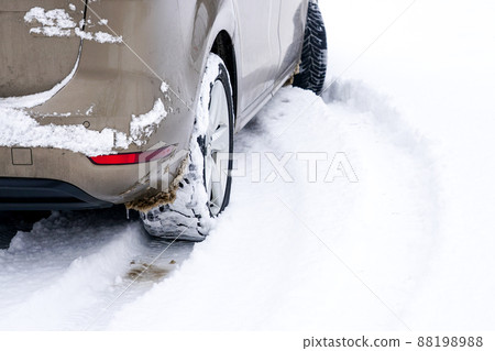 Car tires on winter road covered with snow 88198988