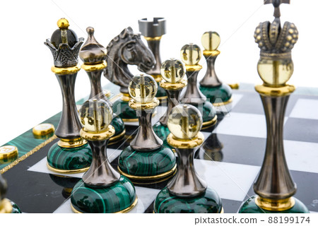 Malachite stone chess pieces on and marble chessboard 88199174