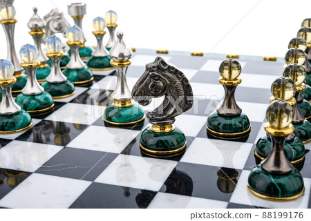 Malachite stone chess pieces on and marble chessboard 88199176