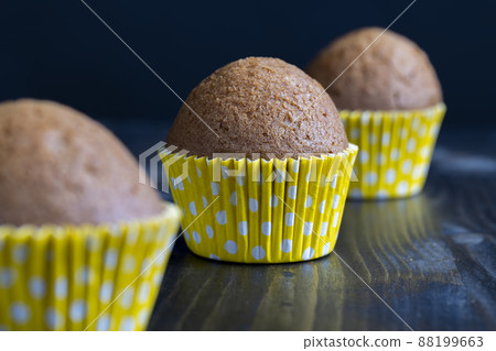 delicious wheat cupcakes on a black wooden table delicious wheat cupcakes on a black wooden table 88199663