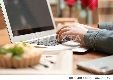 Blogger working with laptop in cafe, closeup 88200459
