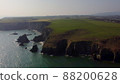 panning over large Atlantic Ocean cliffs with crashing waves in drone flight over Stradbally Cove, Cooper Coast, Waterford, Ireland. 88200628