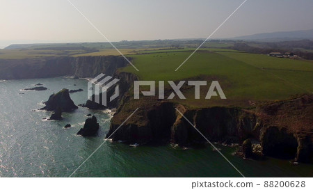 panning over large Atlantic Ocean cliffs with crashing waves in drone flight over Stradbally Cove, Cooper Coast, Waterford, Ireland. panning over large Atlantic Ocean cliffs with crashing waves in drone flight over Stradbally Cove, Cooper Coast, Waterford, Ireland. 88200628