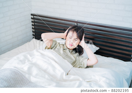 Middle-aged woman in bed (ear hurts) Middle-aged woman in bed (ear hurts) 88202195