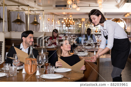 Waitress talking with restaurant guests 88203961