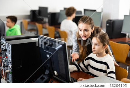 Teacher together with students conduct lesson on computer education 88204195