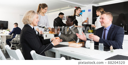business people chatting while enjoying coffee business people chatting while enjoying coffee 88204320