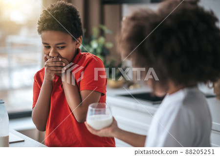 A boy in red shirt refusing from milk A boy in red shirt refusing from milk 88205251