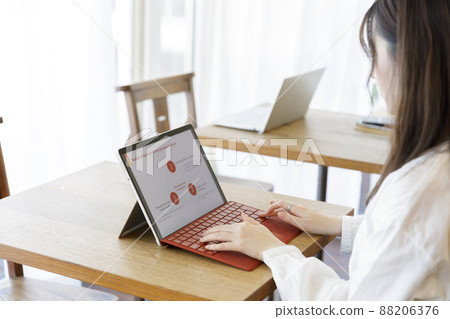 Woman operating a personal computer Woman operating a personal computer 88206376