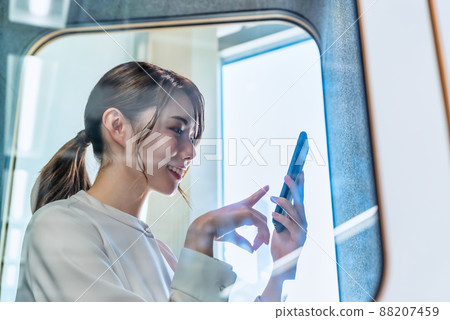 一位女士在免費地址辦公室的隔音電話亭打電話 一位女士在免費地址辦公室的隔音電話亭打電話 88207459